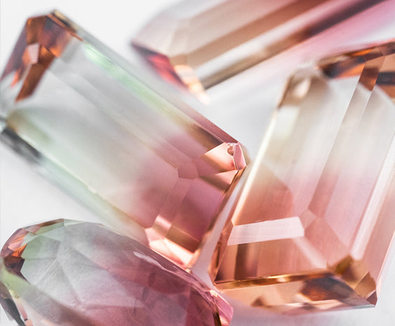 A close-up of a selection of pink, yellow, orange and green bi-colour tourmaline.