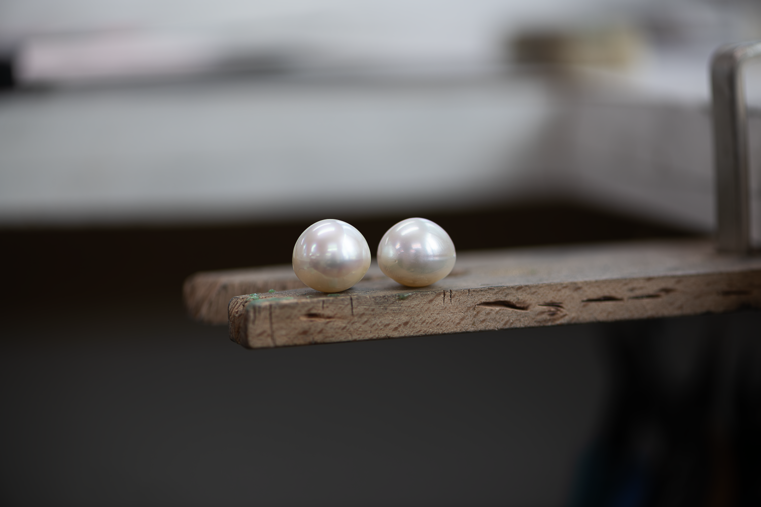 A pair of round golden South Sea pearls are displayed on a white background.