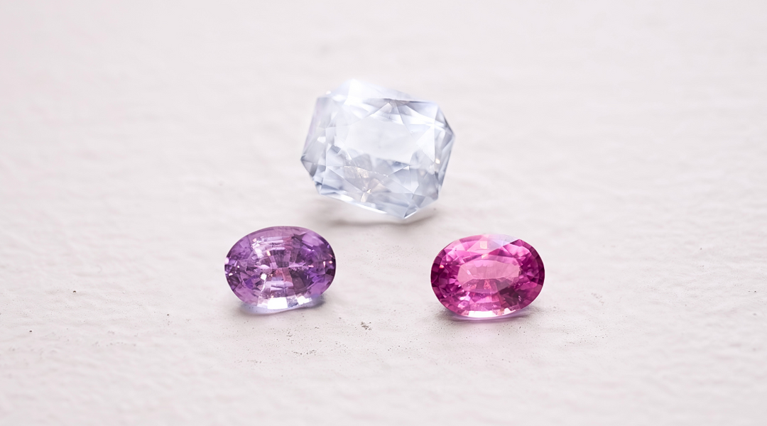 Pink, purple and white sapphires rest on a window ledge.