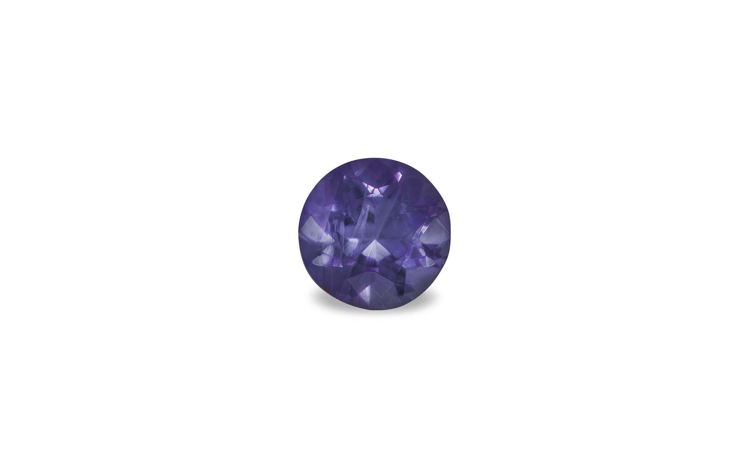 An round brilliant cut Burmese sapphire gemstone is displayed on a white background.