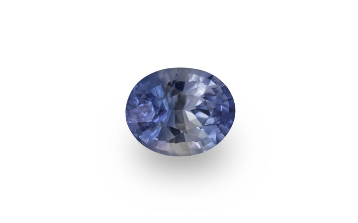 An oval cut blue Ceylon sapphire gemstone is displayed on a white background.