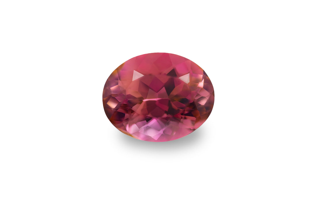 An oval cut pink tourmaline gemstone is displayed on a white background.