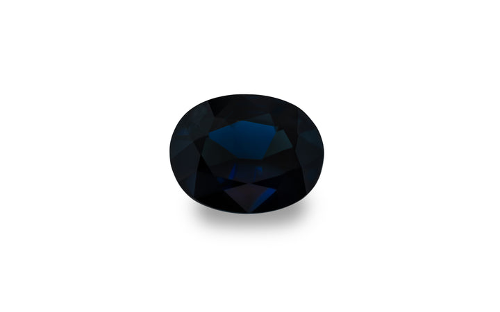 An oval cut, royal blue Australian sapphire is displayed on a white background.
