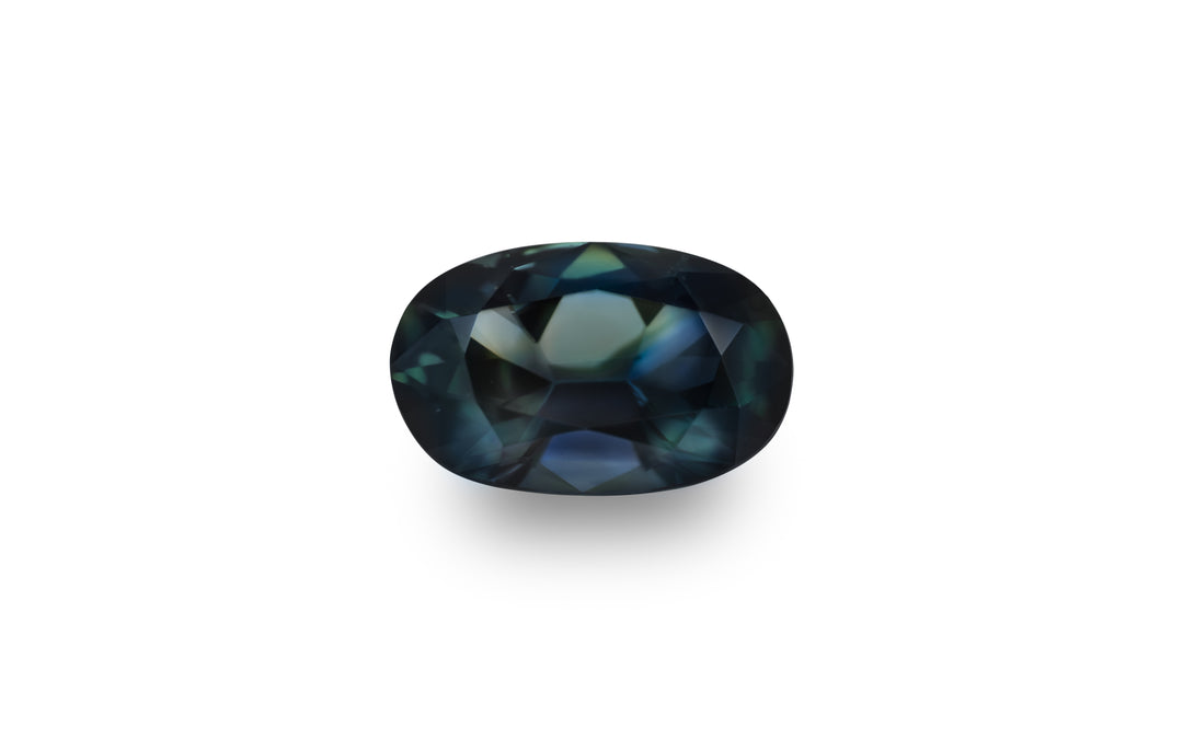 An oval cut, teal blue Australian sapphire is displayed on a white background.