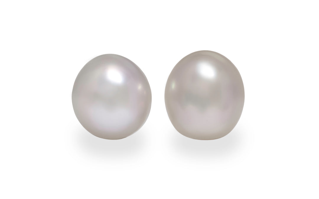 A pair of oval pink white south sea pearls are displayed on a white background.