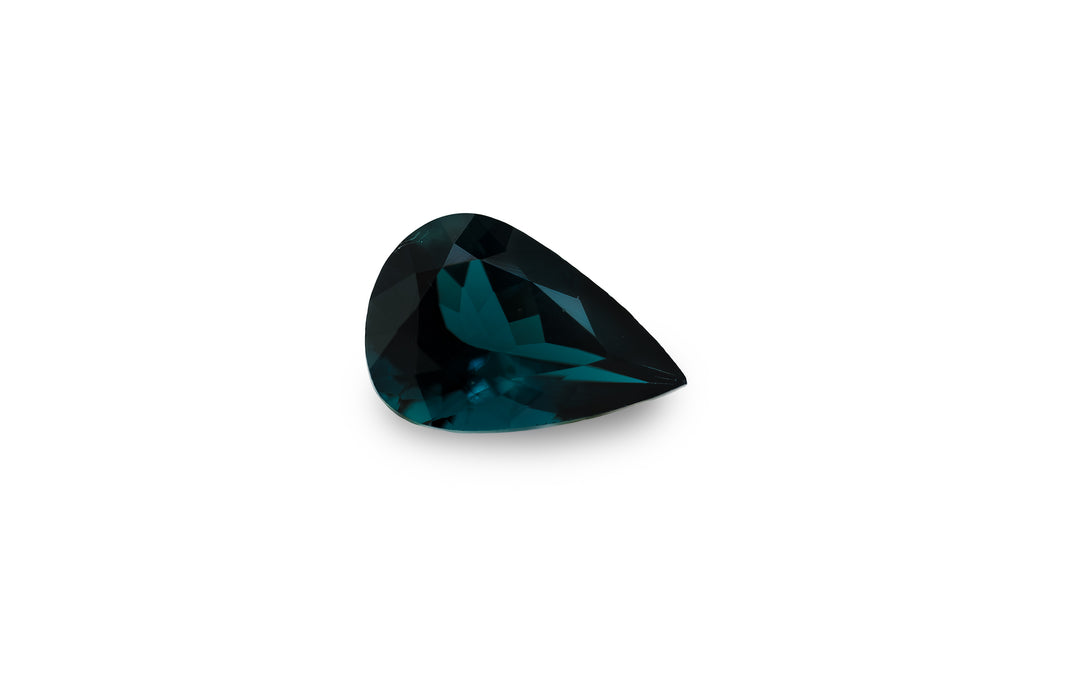 A pear cut blue tourmaline gemstone is displayed on a white background.