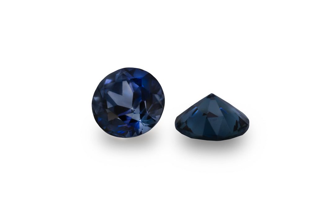 A round brilliant cut blue Ceylon sapphire gemstone is displayed on a white background.