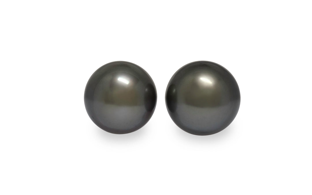 A pair of semi round silver green Tahitian pearls are displayed on a white background.
