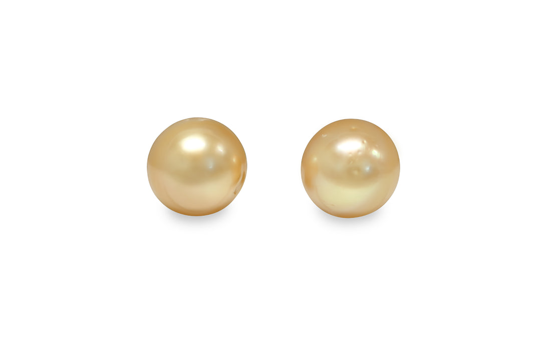 A button shape deep Golden South Sea pearl pair is displayed on a white background.