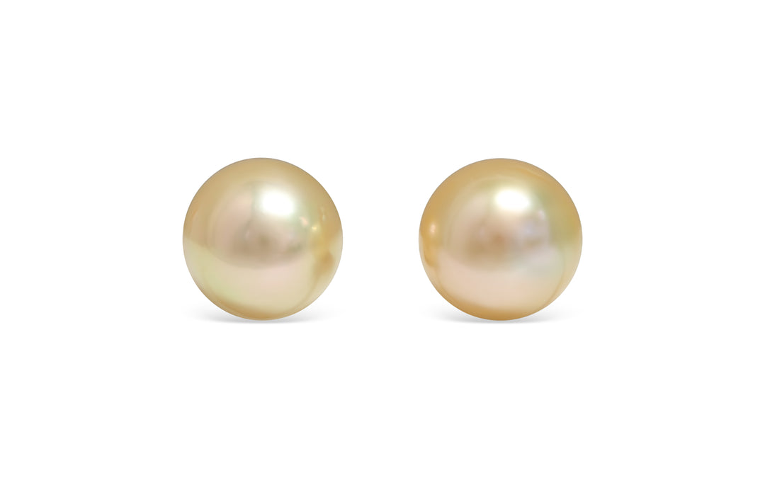 A button shape deep Golden South Sea pearl pair is displayed on a white background.
