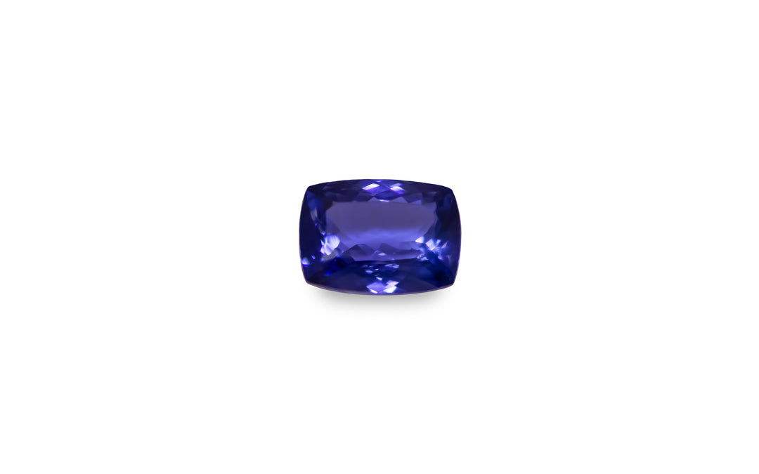 A cushion cut purple blue Tanzanite gemstone is displayed on a white background.
