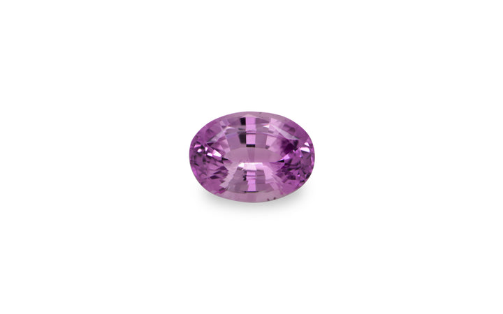 An oval cut purple Ceylon sapphire gemstone is displayed on a white background.