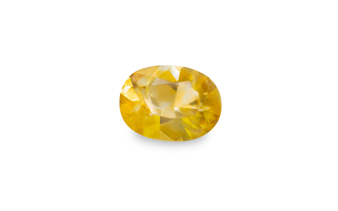 A cushion cut yellow sapphire gemstone is displayed on a white background.