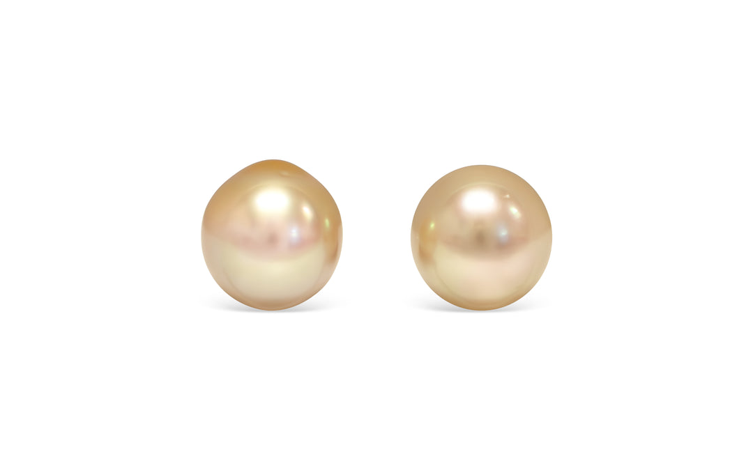 A drop shape deep Golden South Sea pearl pair is displayed on a white background.