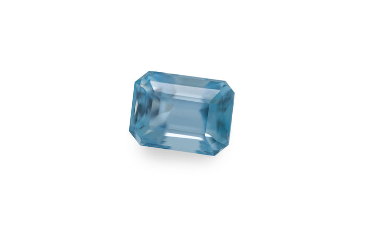 An emerald cut aquamarine gemstone is displayed on a white background.
