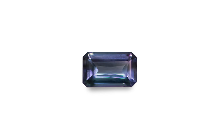 An emerald cut bi colour purple, blue, green Tanzanite is displayed on a white background.