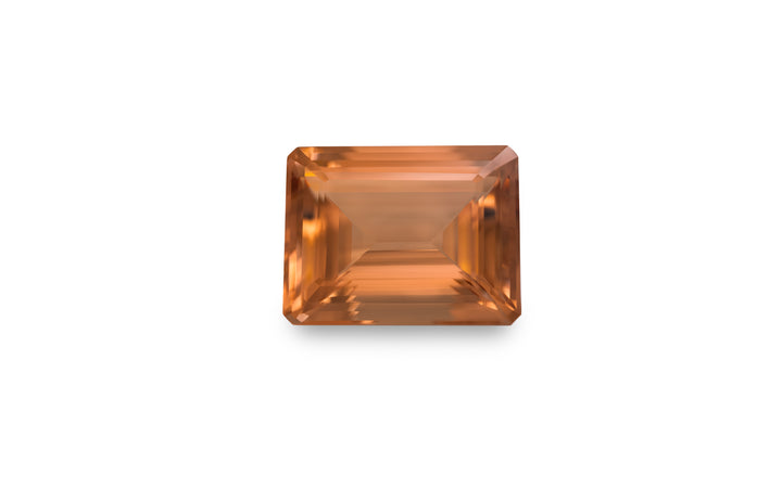 An emerald cut peach morganite gemstone is displayed on a white background.