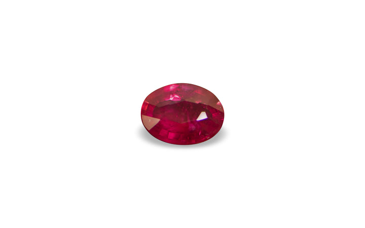 A cushion cut Burmese ruby is displayed on a white background. 