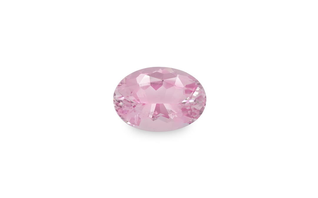 An oval cut pink morganite gemstone is displayed on a white background.
