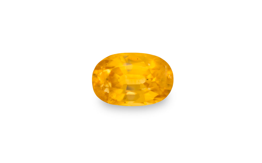  An oval cut yellow sapphire gemstone is displayed on a white background.