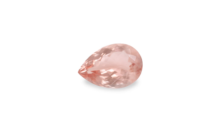 A pear cut peach morganite gemstone displayed on a white background.