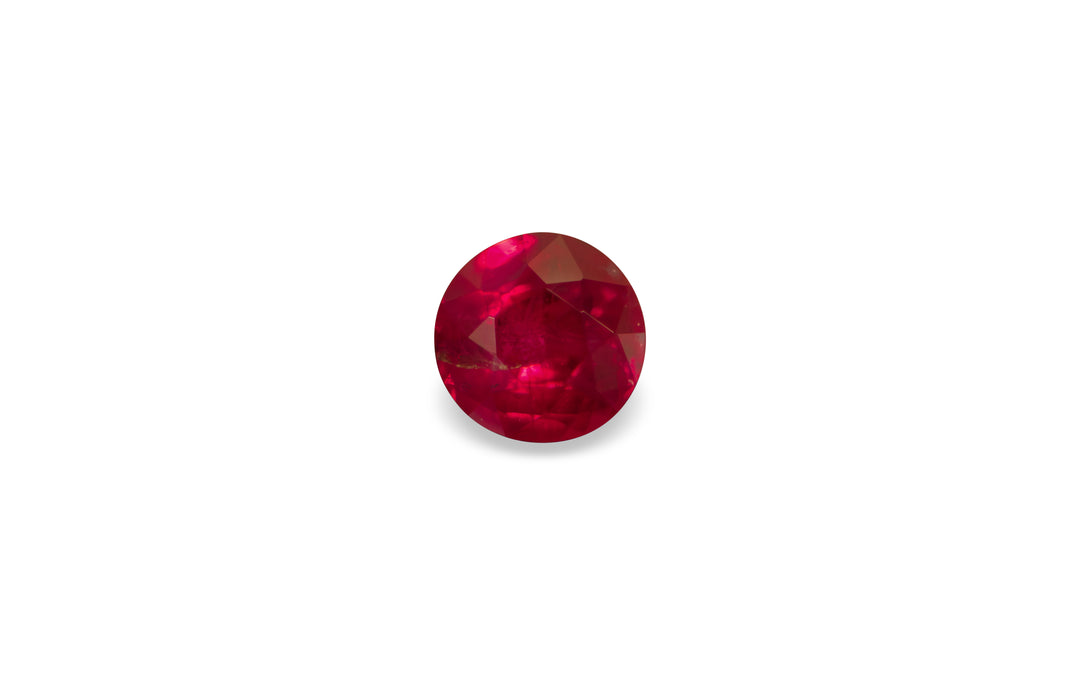 A round brilliant cut Burmese ruby gemstone is displayed on a white background.