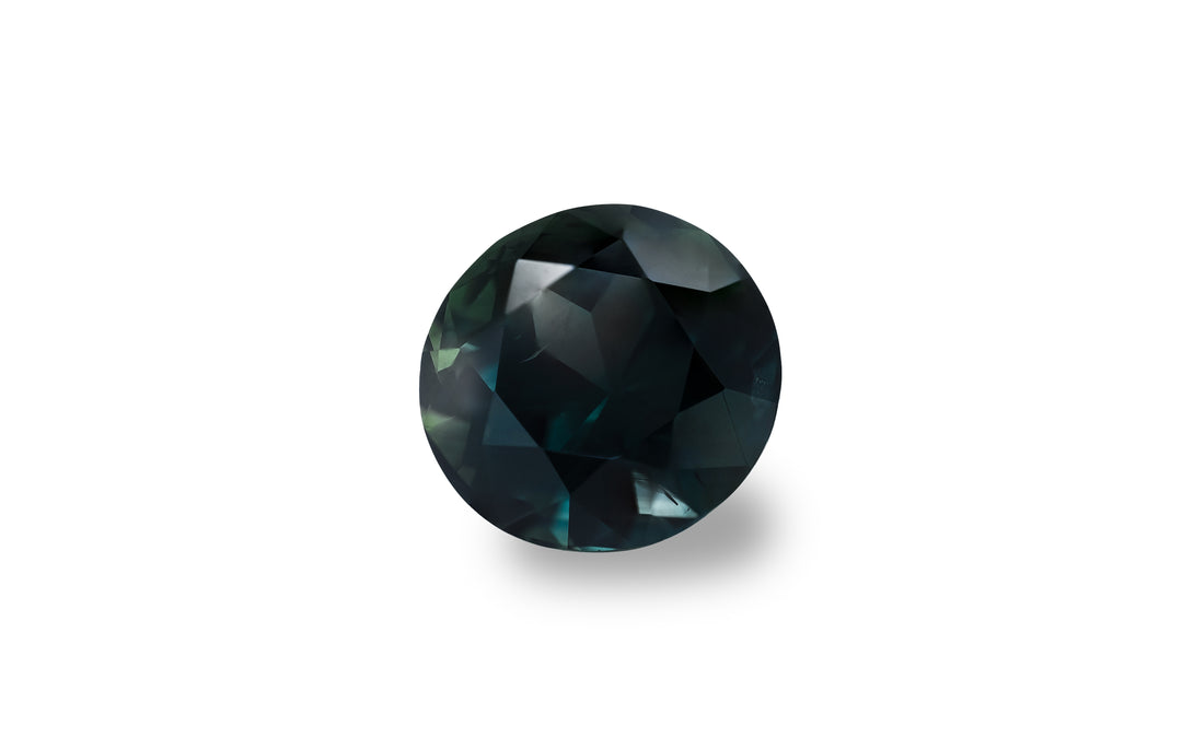 A round brilliant cut deep blue Australian sapphire is displayed on a white background.