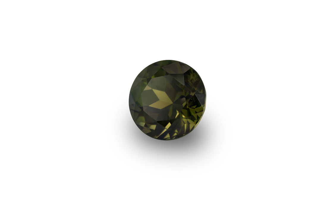 A round brilliant cut, olive green Australian sapphire gemstone is displayed on a white background.