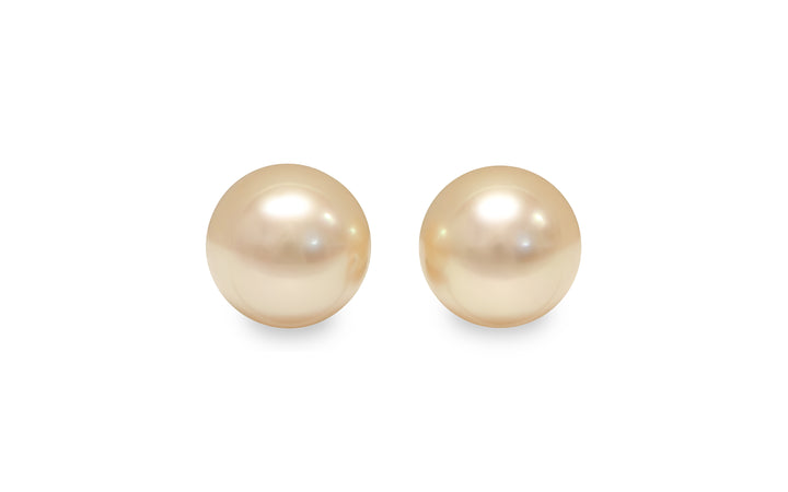 A round light Golden South Sea pearl pair is displayed on a white background.
