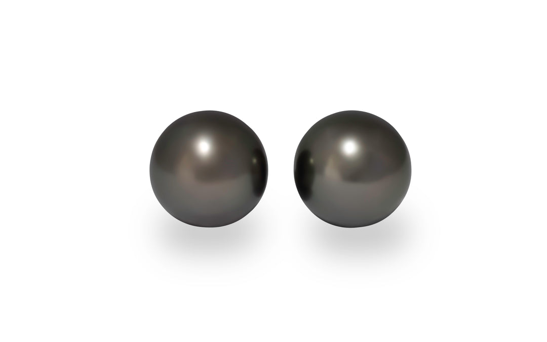 A pair of round Tahitian pearls are displayed on a white background.