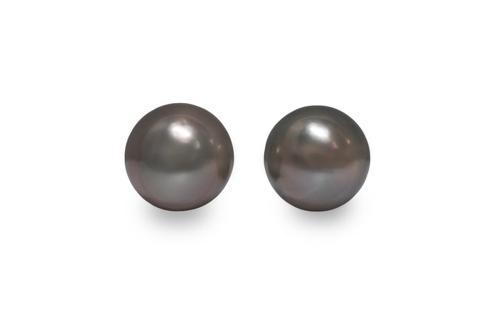 A round shape Tahitian pearl pair is displayed on a white background.
