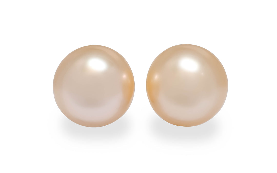 A round shape light gold South Sea pearl pair is displayed on a white background.
