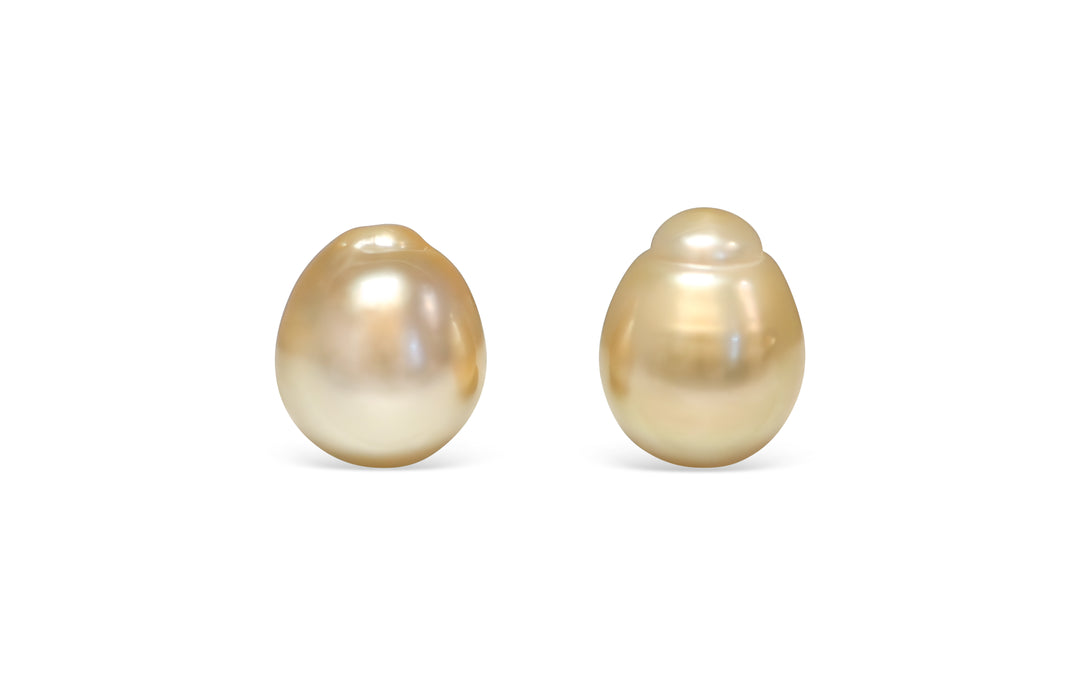 A semi baroque deep light Golden South Sea pearl pair is displayed on a white background.