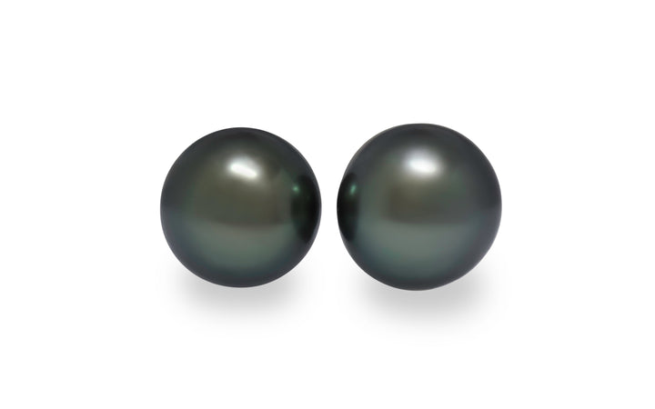 A pair of semi round green Tahitian pearls are displayed on a white background.