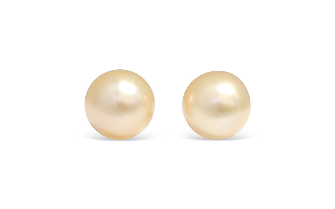 A semi round light Golden South Sea pearl pair is displayed on a white background.
