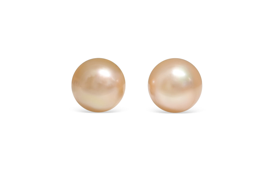 A semi round light Golden South Sea pearl pair is displayed on a white background.
