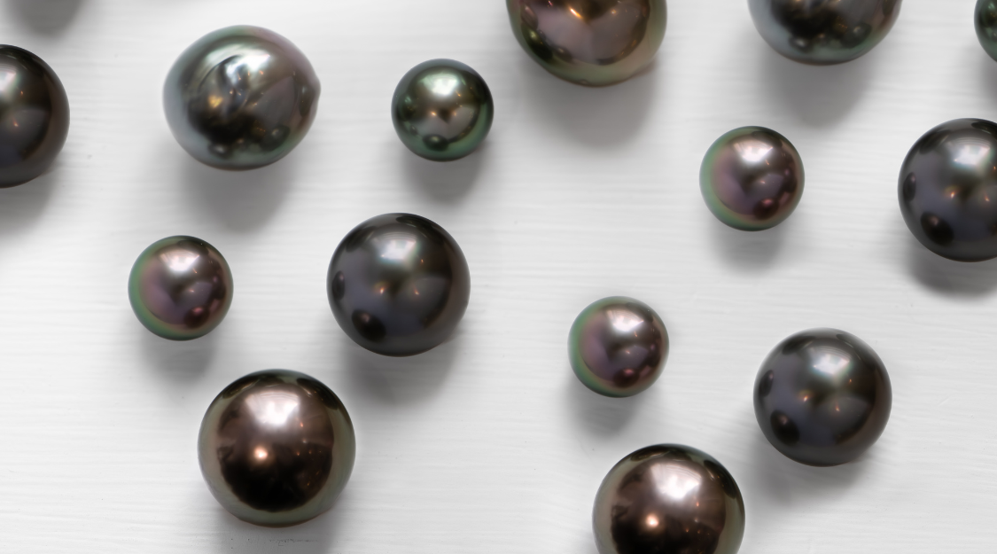 A selection of Tahitian pearls in various shapes rest on window ledge.