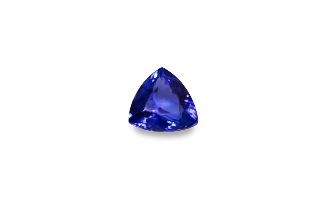 A trillion cut intense blue Tanzanite gemstone is displayed on a white background. 