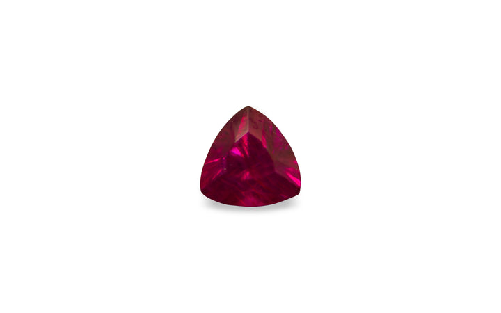 A trillion cut Mozambique ruby gemstone is displayed on a white background.