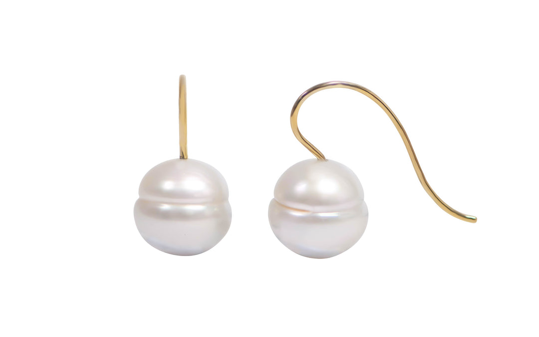 A pair of 18K yellow gold circle white south sea pearl shepherd hook earrings is displayed on a white background.