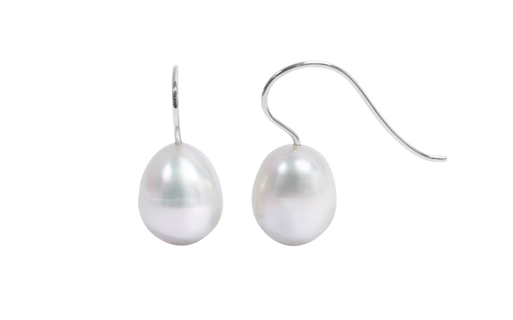 A pair of 18K white gold oval white south sea pearl shepherd hook earrings is displayed on a white background.