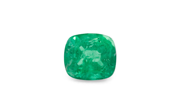 A cushion cut green African emerald gemstone is displayed on a white background.