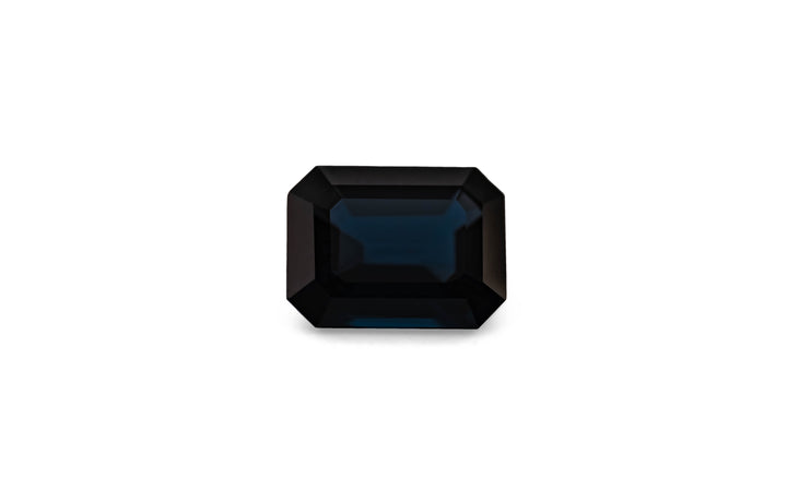 An emerald cut blue spinel gemstone is displayed on a white background.