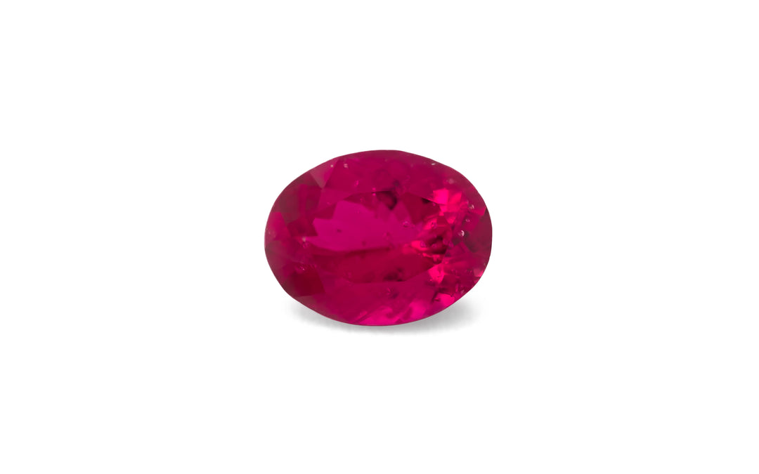 An oval cut pink Burmese spinel gemstone is displayed on a white background.