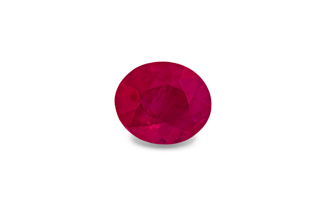  An oval cut, red Burmese ruby gemstone is displayed on a white background.