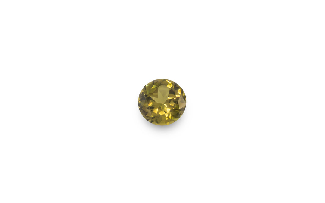A round cut green Australian sapphire gemstone is displayed on a white background.