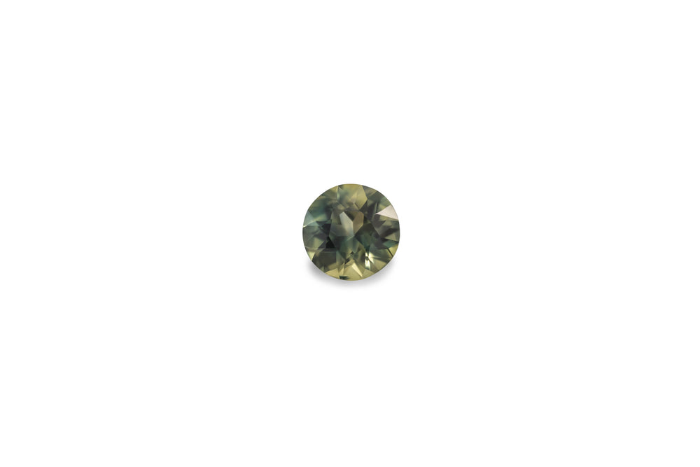 A round cut green blue Australian sapphire gemstone is displayed on a white background.