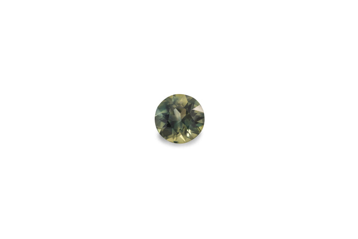 A round cut green blue Australian sapphire gemstone is displayed on a white background.
