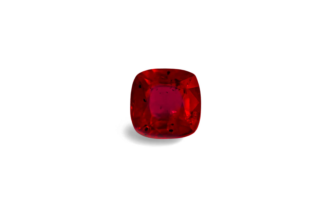 A square cushion cut, red Burmese ruby gemstone is displayed on a white background.