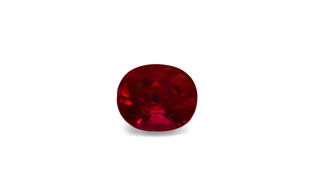 A cushion cut red spinel gemstone is displayed on a white background.